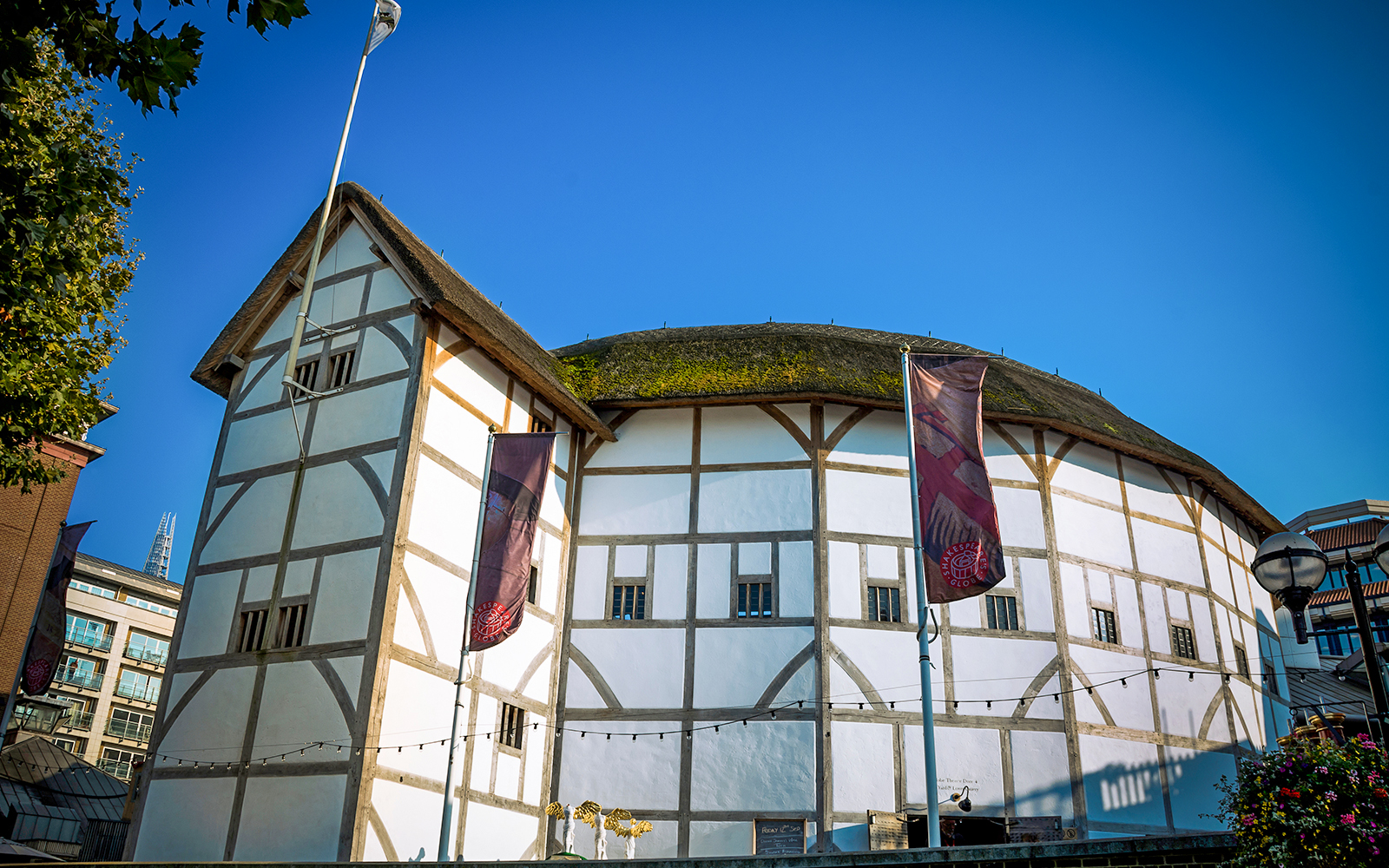 Shakespeare's Globe Theatre exterior in London with tourists gathered outside.
